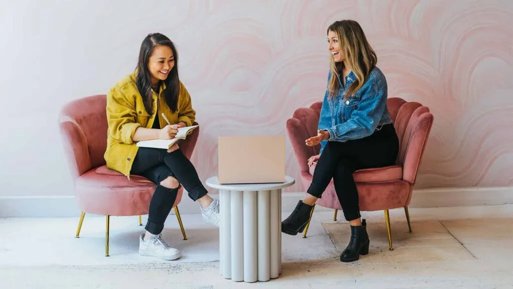 two women sitting in chairs and talking Rising-Interest-Rates